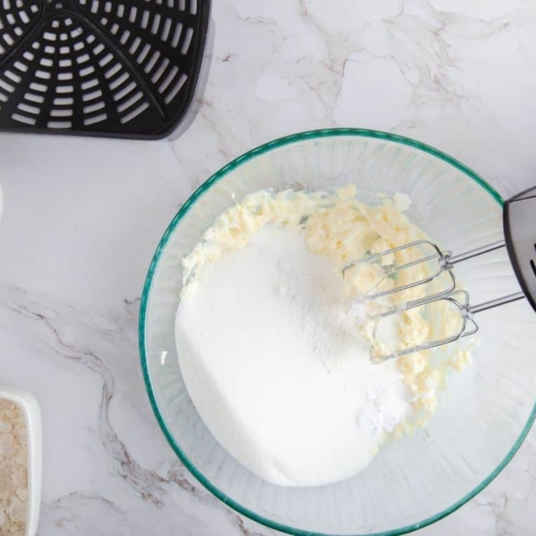 Mixing flour, baking powder, butter, powdered sugar, egg yolk, brandy, and vanilla extract in a large bowl
