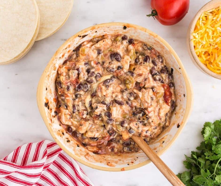 Mixing black beans, cream of chicken soup, and fire-roasted tomatoes in a large bowl.