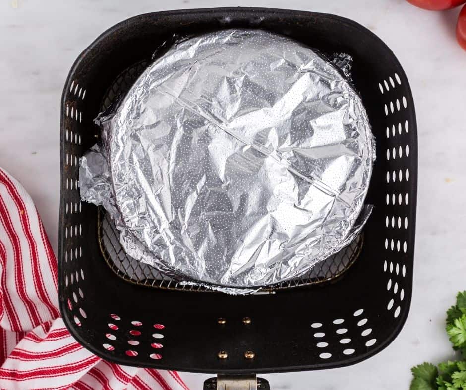 Topping the casserole with shredded Colby-Jack cheese and tortilla chips.