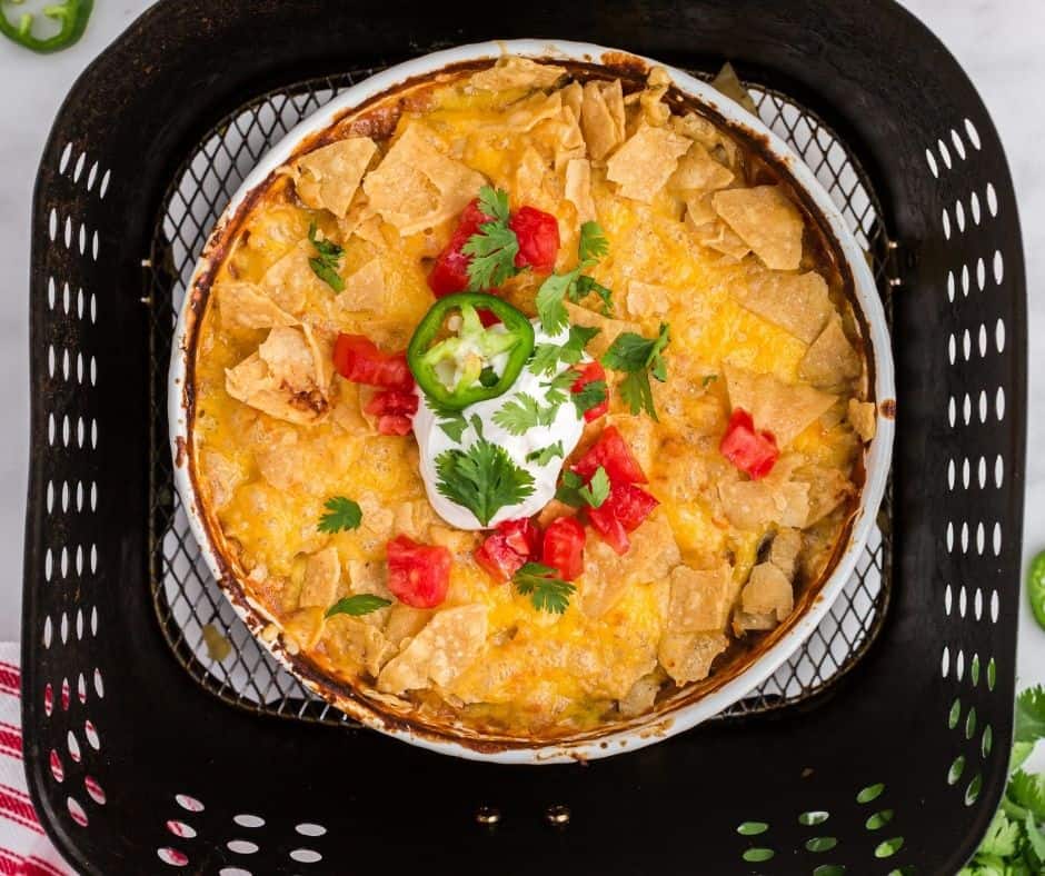 "Finished air fryer Mexican chicken casserole served with fresh cilantro and sour cream.