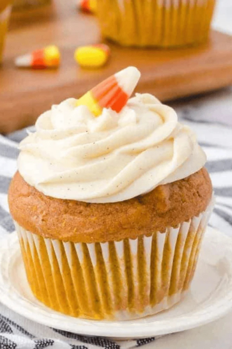 Close-up of a frosted air fryer pumpkin spice cupcake with the liner peeled back