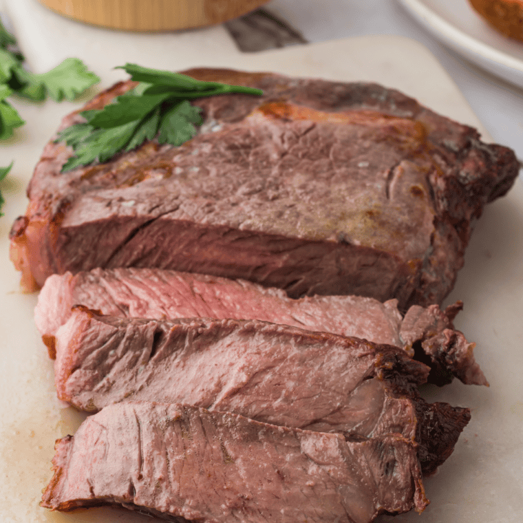 Cooked medium-rare air fryer ribeye steak resting on a cutting board with foil