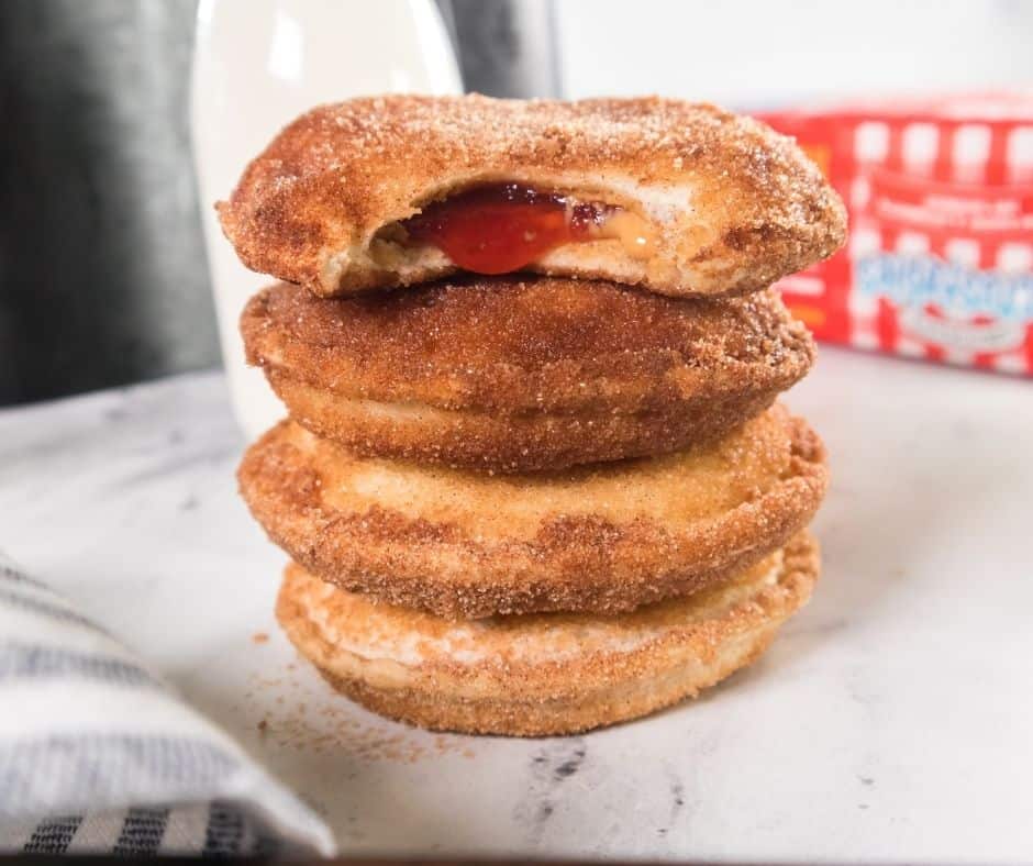Plate of golden, cinnamon sugar-coated Air Fryer Uncrustable Donuts ready to serve