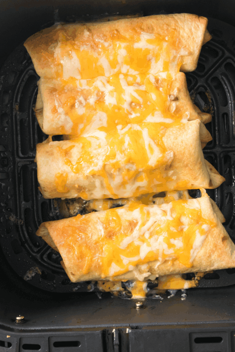 Air fryer chicken chimichangas, golden and crispy, served with dipping sauce on a plate.