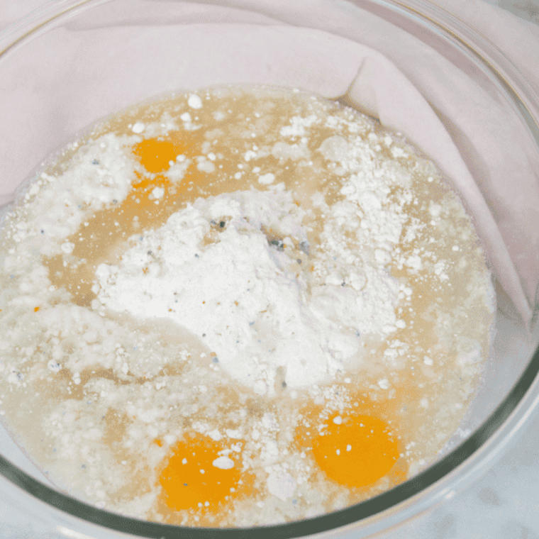 Mixing bowl with wet and dry ingredients combined into smooth cake batter.