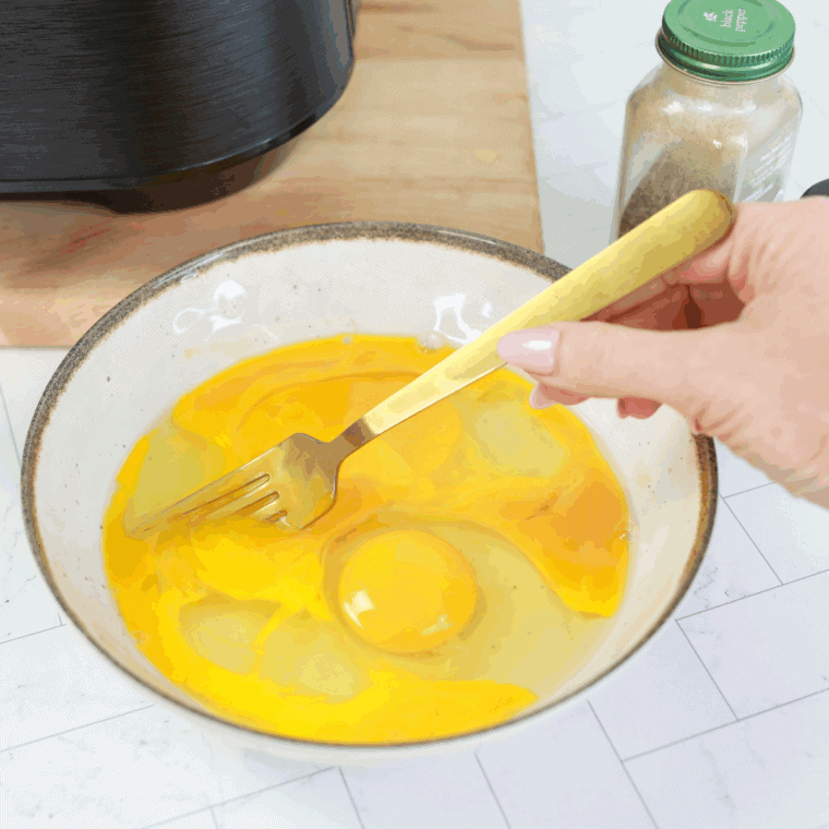 Whisking eggs and milk together until frothy in bowl.
