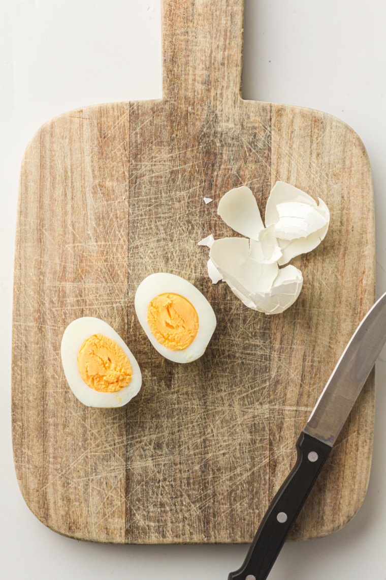 Peeling Instant Pot hard-boiled eggs and slicing them in half for deviled eggs