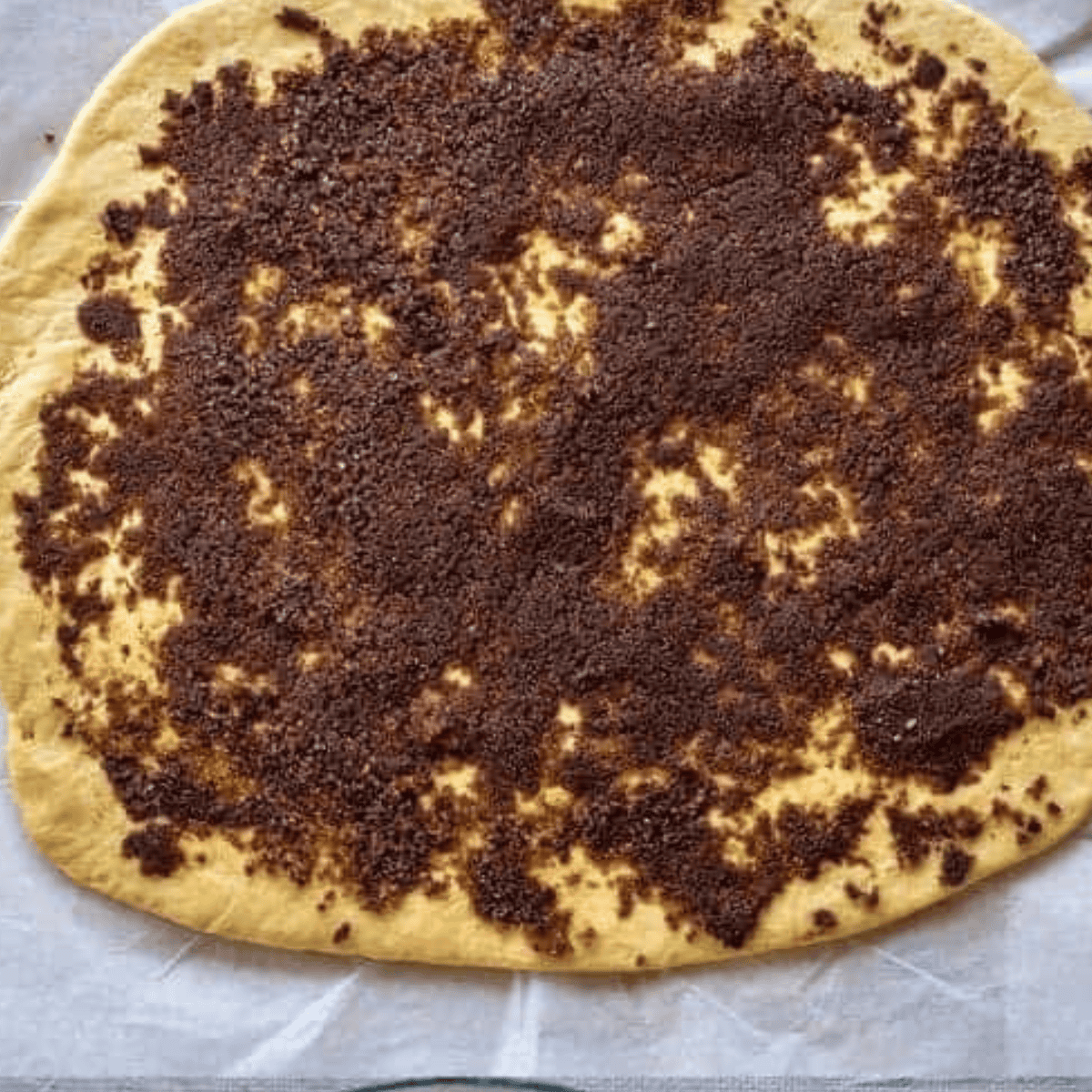 Rolling out the dough and adding your cinnamon topping on top.