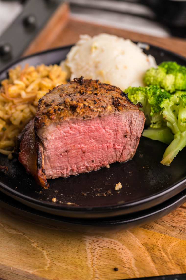 Close-up of air fryer beef tenderloin filet mignon with garlic butter melting over the top.