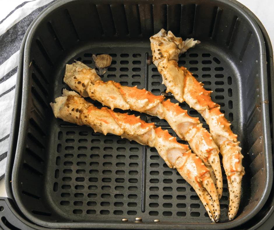 Cooked crab legs in an air fryer basket, ready to serve.