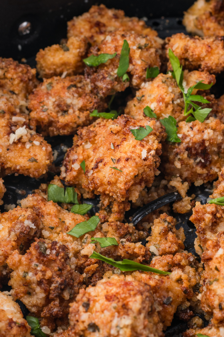 Chicken bites coated in garlic butter parmesan sauce and topped with fresh parsley