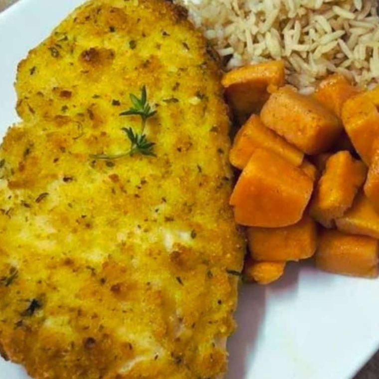 Golden and crispy herb-crusted chicken breasts cooked in an air fryer, served on a white plate.