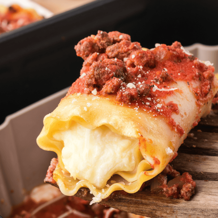 Crispy Air Fryer Lasagna Rolls filled with ricotta and marinara, topped with melted cheese on a plate.