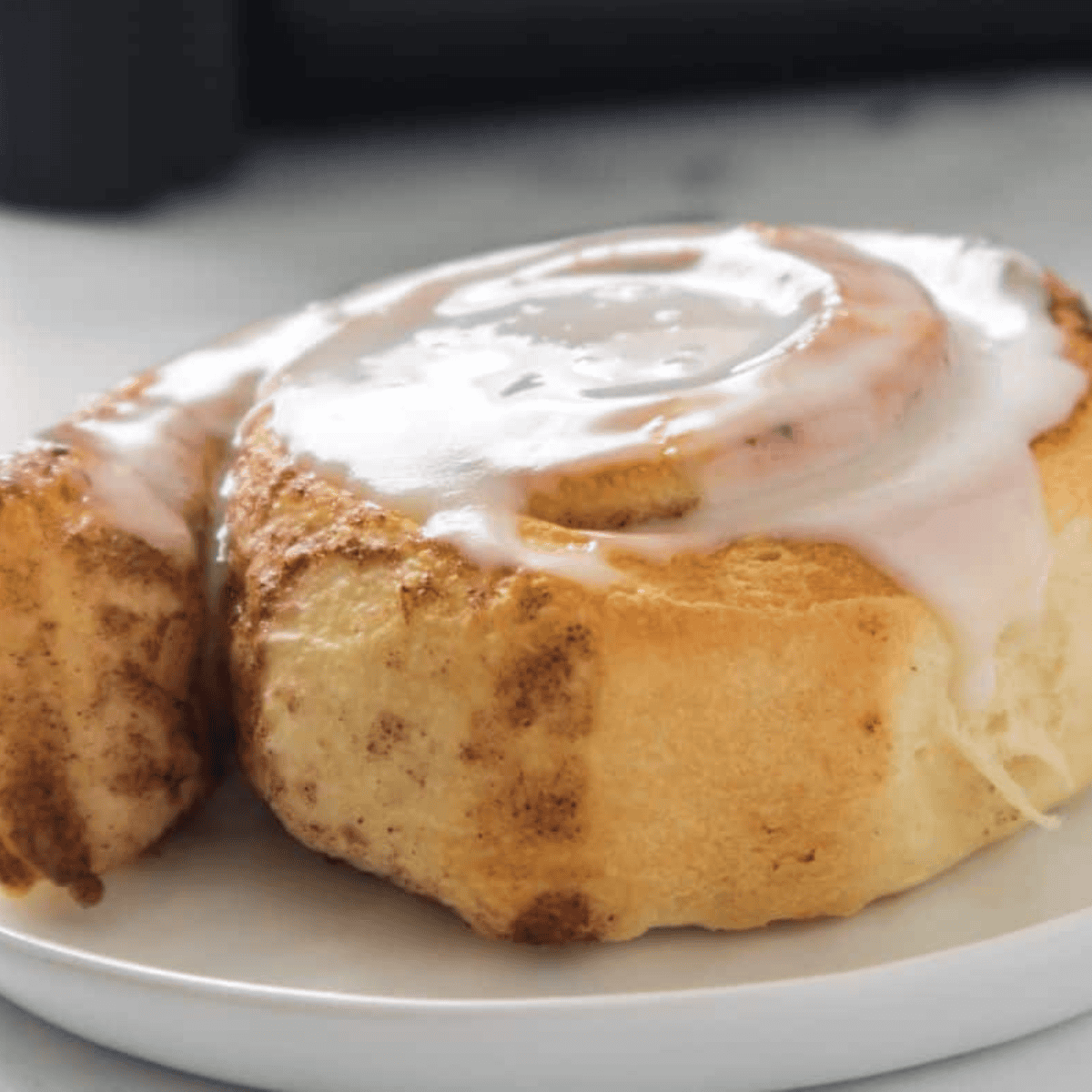 Fluffy Pillsbury cinnamon rolls cooked in the air fryer and drizzled with sweet icing