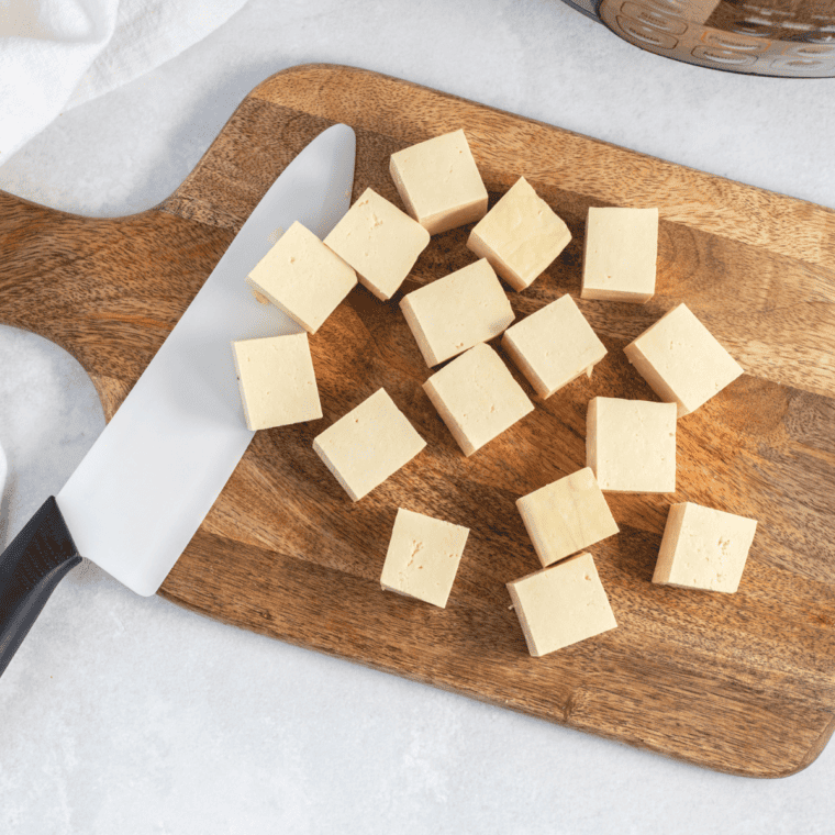 Image of diced tofu cubes seasoned with salt and pepper before cooking
