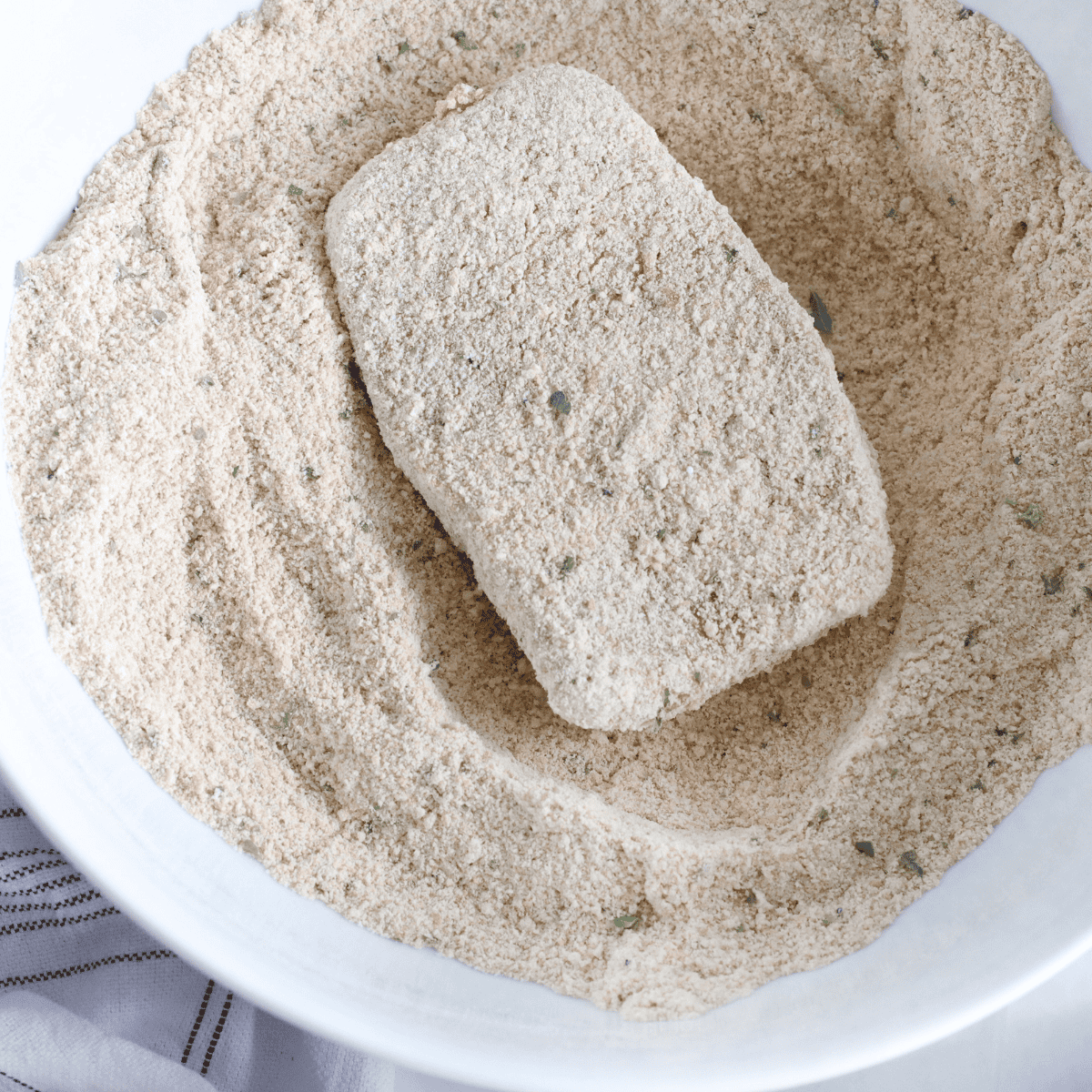 Dipping pork chops into flour, egg mixture, and seasoned flour coating.