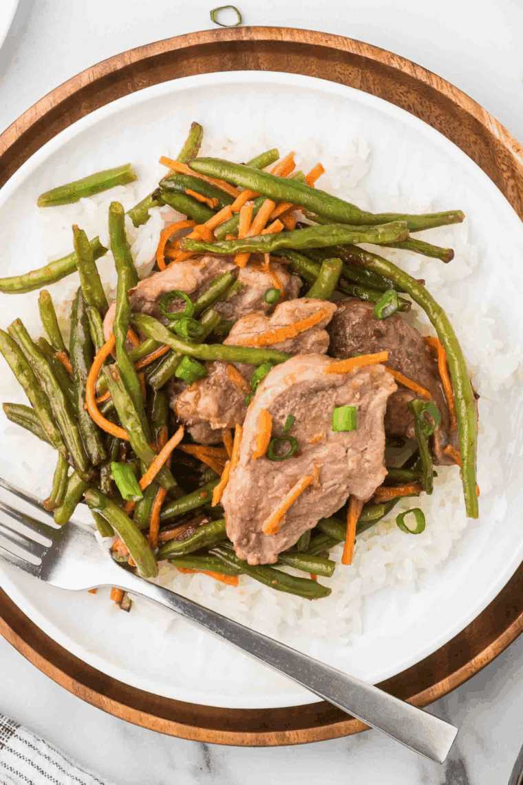 Juicy air fryer teriyaki pork chops served on a plate with rice and vegetables, golden brown and glazed.