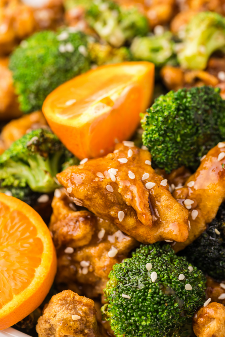 Sliced chicken breast and charred crispy broccoli florets served together on a white plate