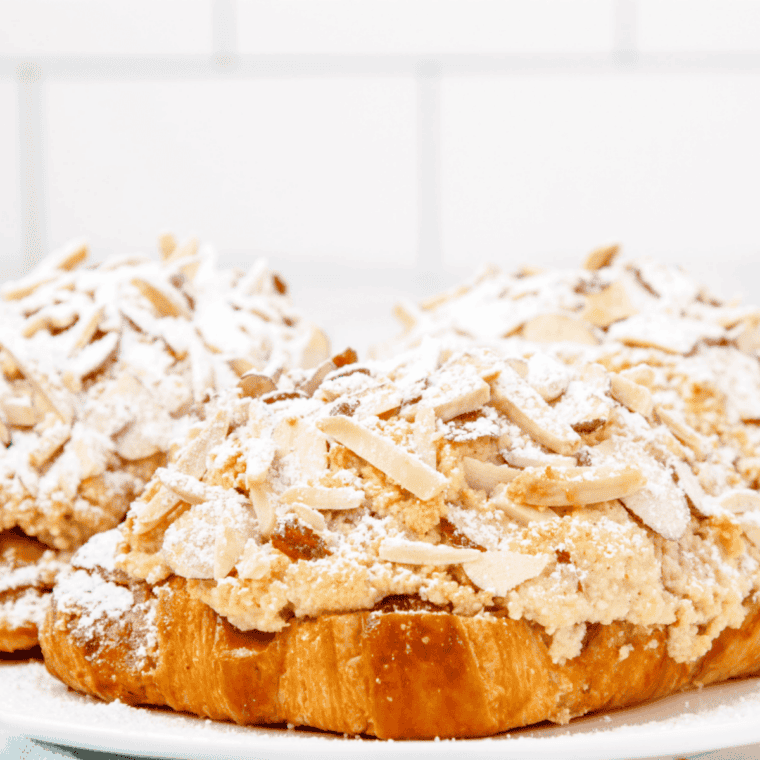 Almond croissant topped with sliced toasted almonds and powdered sugar