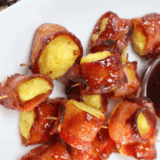 Air Fryer Bacon Wrapped Pineapple bites with crispy bacon and caramelized edges, served on a white plate.