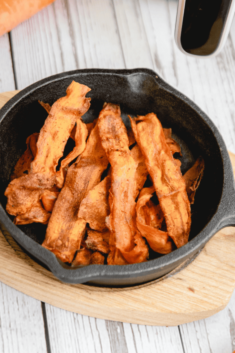Close-up of smoky air fryer carrot bacon with crispy curled edges