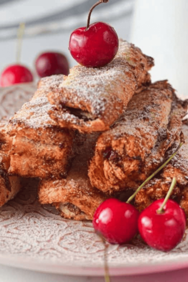 Air fryer French toast stuffed with Nutella and cherries, golden and crispy on a plate