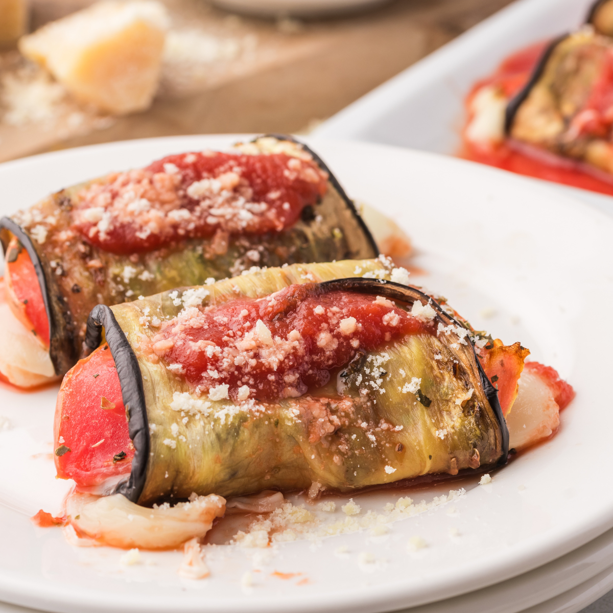 Plate of Air Fryer Eggplant Rollatini with melted mozzarella, tomato slices, and fresh basil.