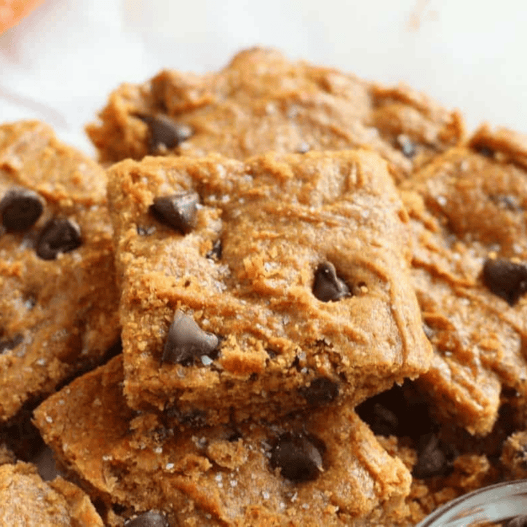 Plate of air fryer flourless peanut butter blondies topped with chocolate chips and flaky sea salt.
