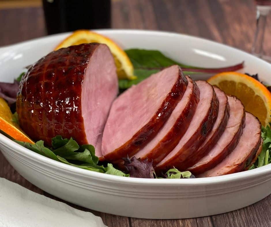 Air Fryer Honey Glazed Baked Ham with a glossy, golden caramelized glaze, served on a platter with garnishes.