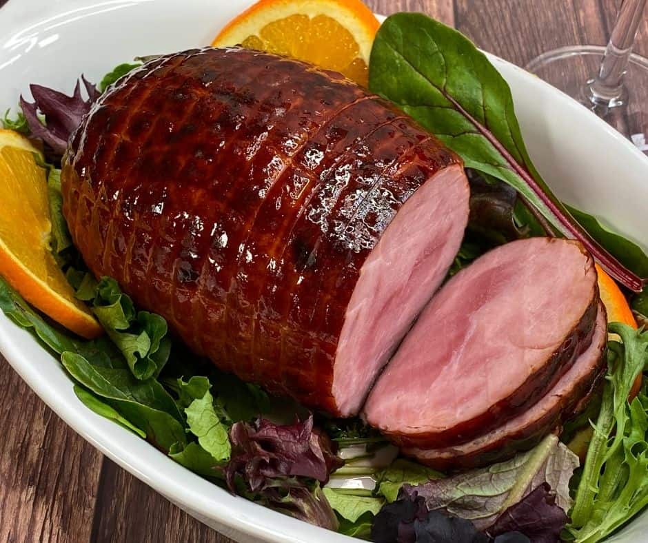 Air Fryer Honey Glazed Baked Ham with a golden, glossy glaze, served on a platter with garnishes.