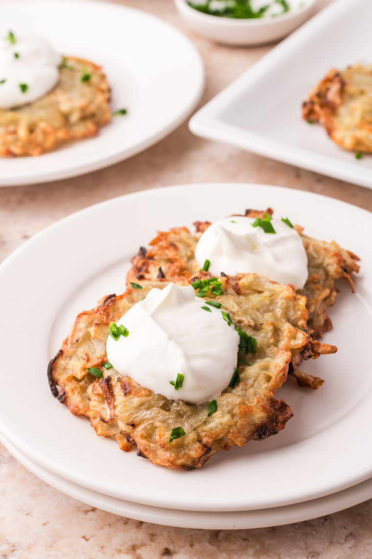Air fryer potato latkes stacked crispy and golden on serving dish