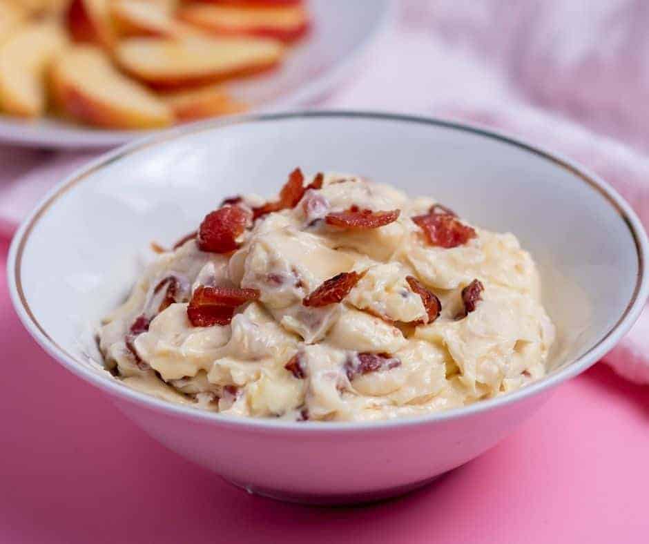 Cheesy Air Fryer Maple Bacon Dip served hot with crackers and fresh chives.