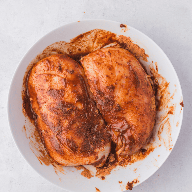 Raw chicken breasts rubbed with olive oil, salt, pepper, and garlic powder