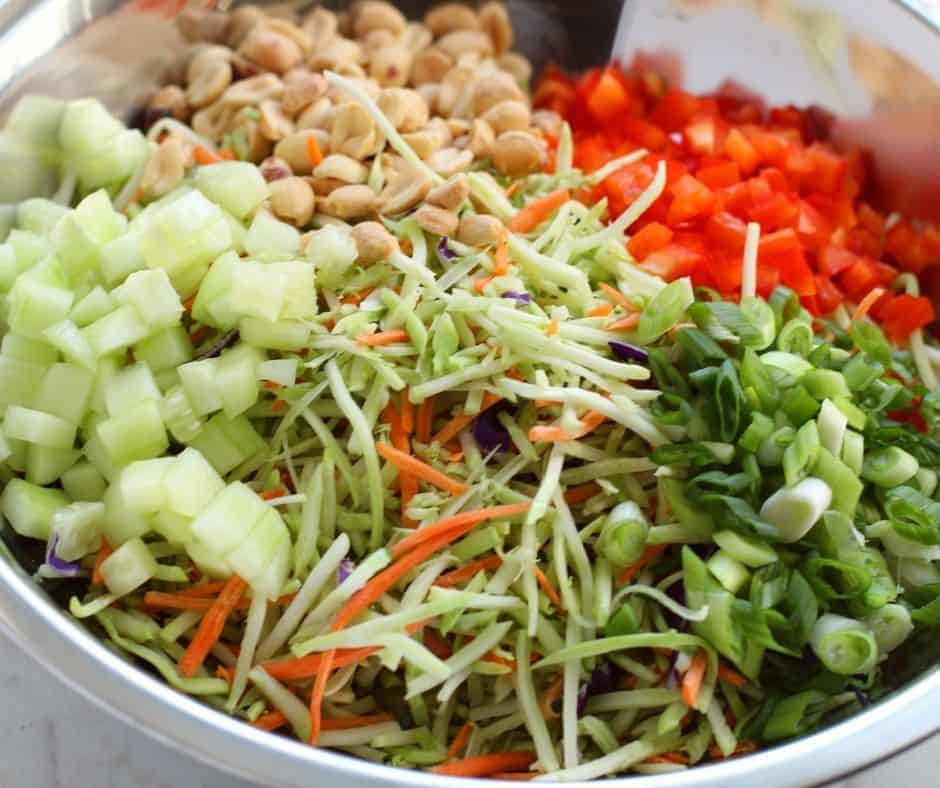 "Grilled chicken pieces being added to the Thai salad mix."
