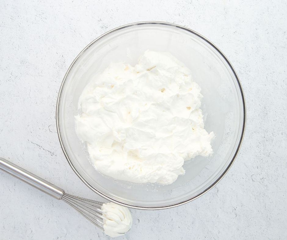 Whisk heavy cream, powdered sugar, and vanilla extract until peaks form for whipped cream filling.