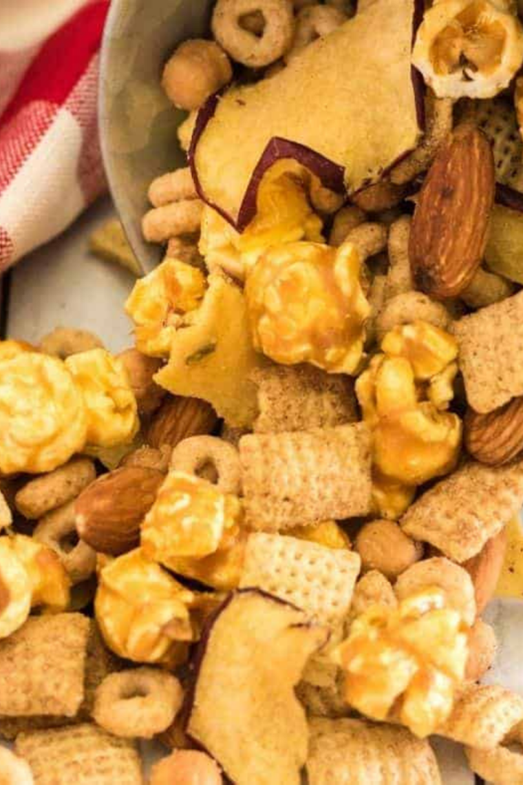 Plate of caramel apple trail mix with cinnamon Chex, apple chips, almonds, and caramel bits