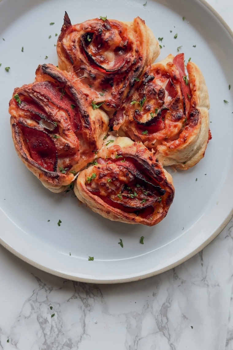 Golden-brown air fryer pepperoni pizza rolls on a plate, crispy outside and gooey inside, ready to serve.