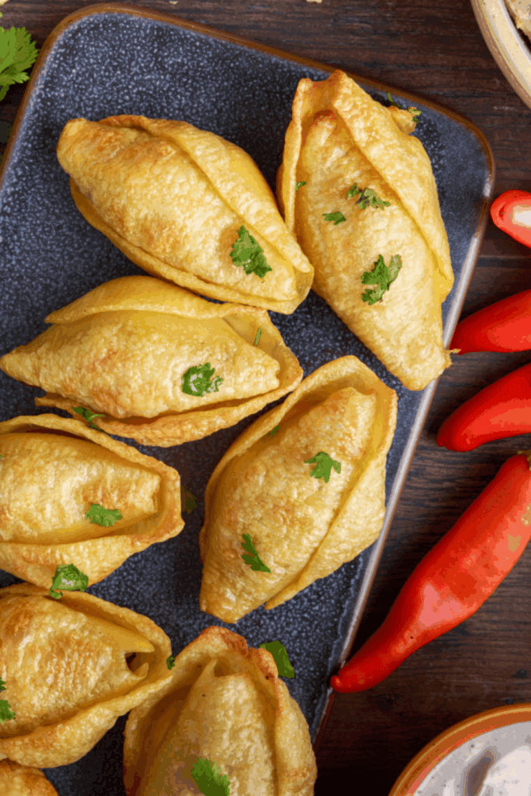 Air fryer taco stuffed pasta shells filled with seasoned beef and topped with melted cheese on a serving plate.