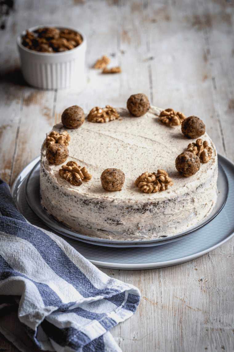 Easy air fryer walnut cake with chopped walnuts on top, sliced and served on a plate.