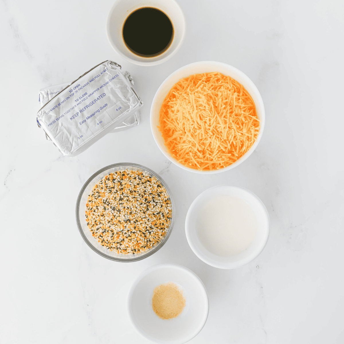 Ingredients needed for Everything Bagel Cheese Ball on kitchen table.