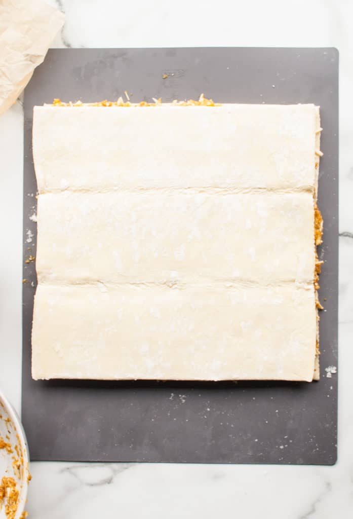 Shredded cheese and basil pesto sprinkled on top of the pumpkin puree, creating layers of flavor for the twists.