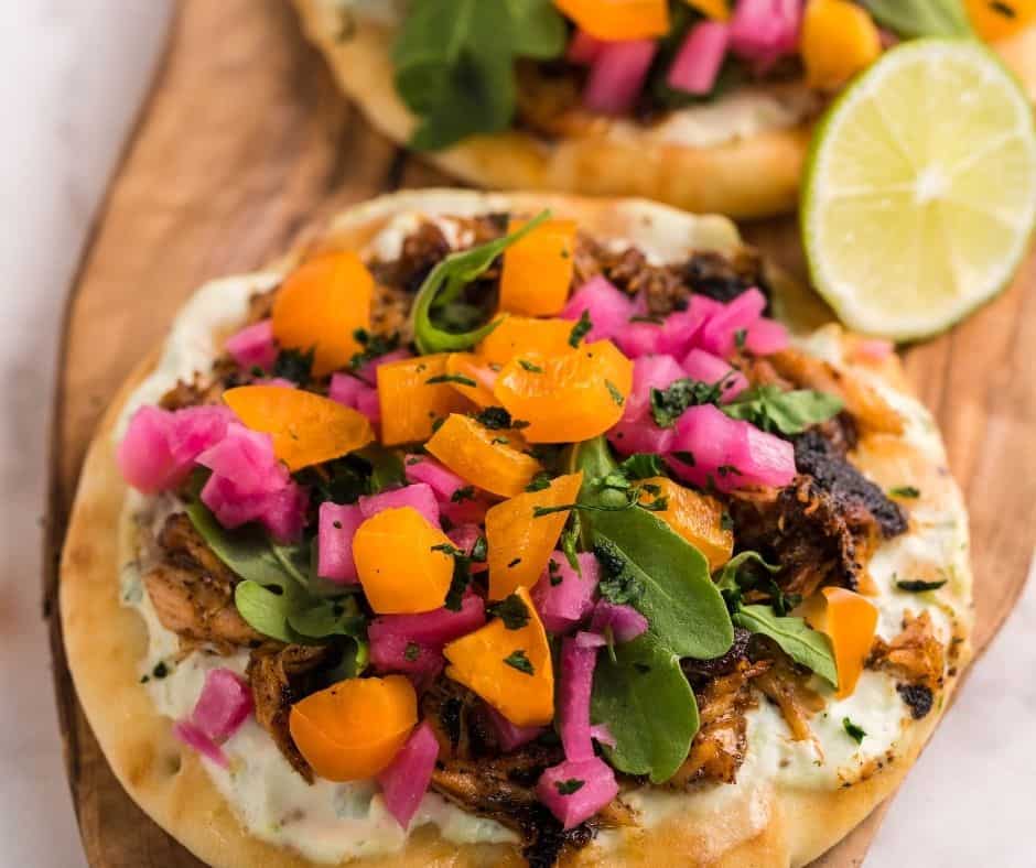 Air Fryer Salmon Tacos with crispy salmon, fresh toppings like arugula, pickled red onions, and cilantro, served in soft tortillas.