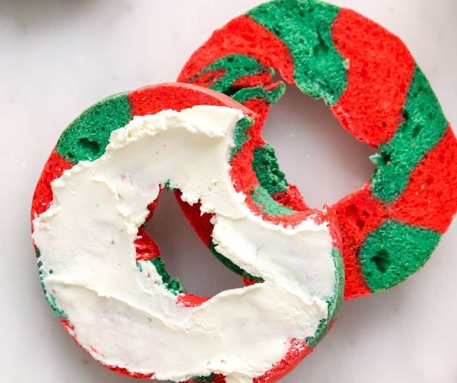 Plate of air fryer Christmas bagels with vibrant red and green toppings, ready for the holiday season