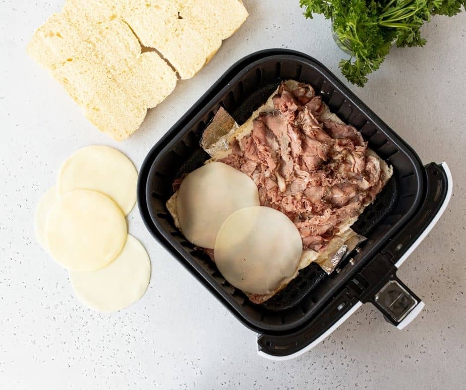 Add shredded beef on top of the mayonnaise, followed by a tablespoon or two of beef mixture, mozzarella cheese, and place the top slider roll over the filling.