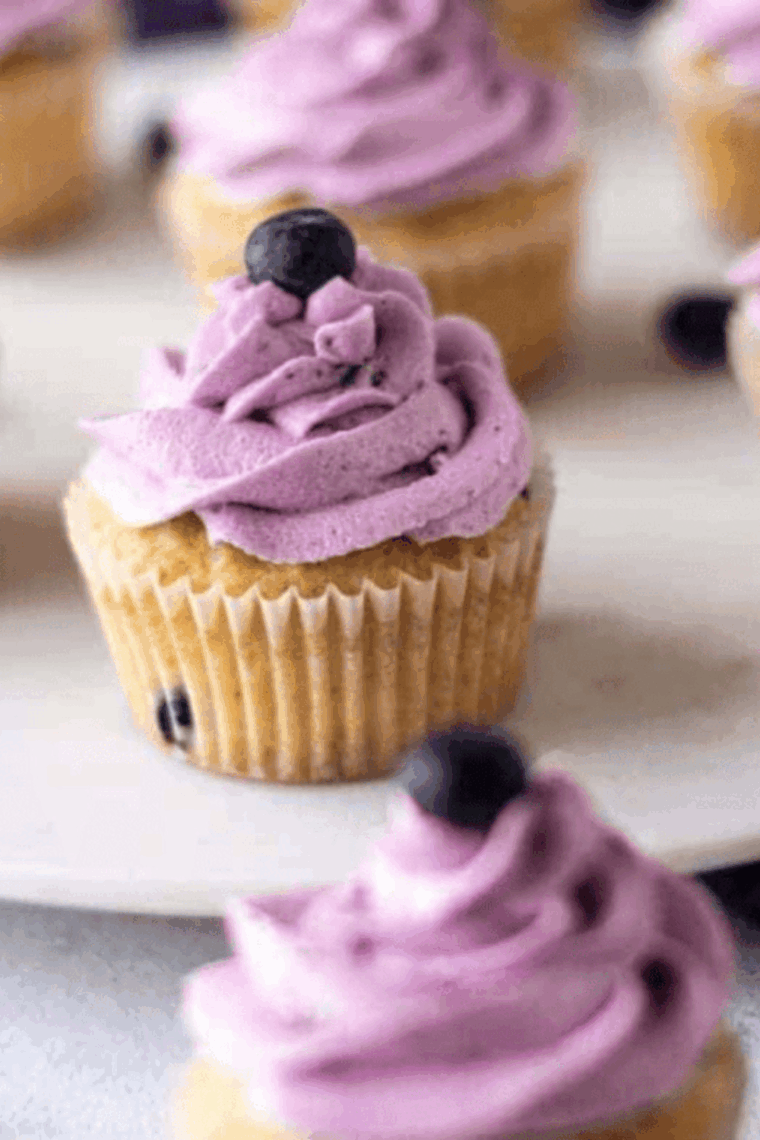 Air fryer blueberry cupcakes in paper liners, golden and fluffy, with blueberries on top.