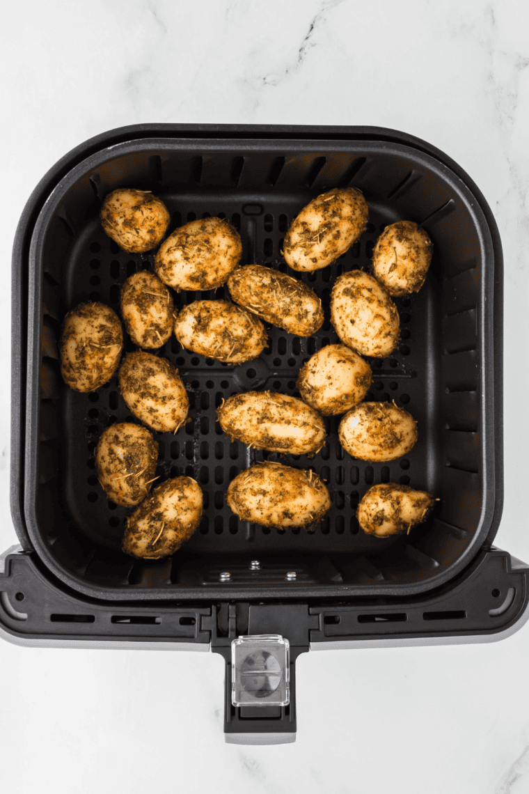 Preheating air fryer to 400°F, then cooking seasoned canned potatoes in a single layer until golden brown and crispy, shaking halfway through.