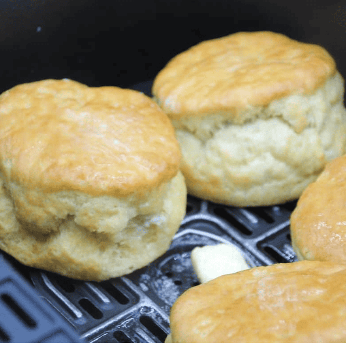 Air fry refrigerated biscuits at 320°F for 5 to 8 minutes, flipping halfway and brushing with butter for a golden finish.