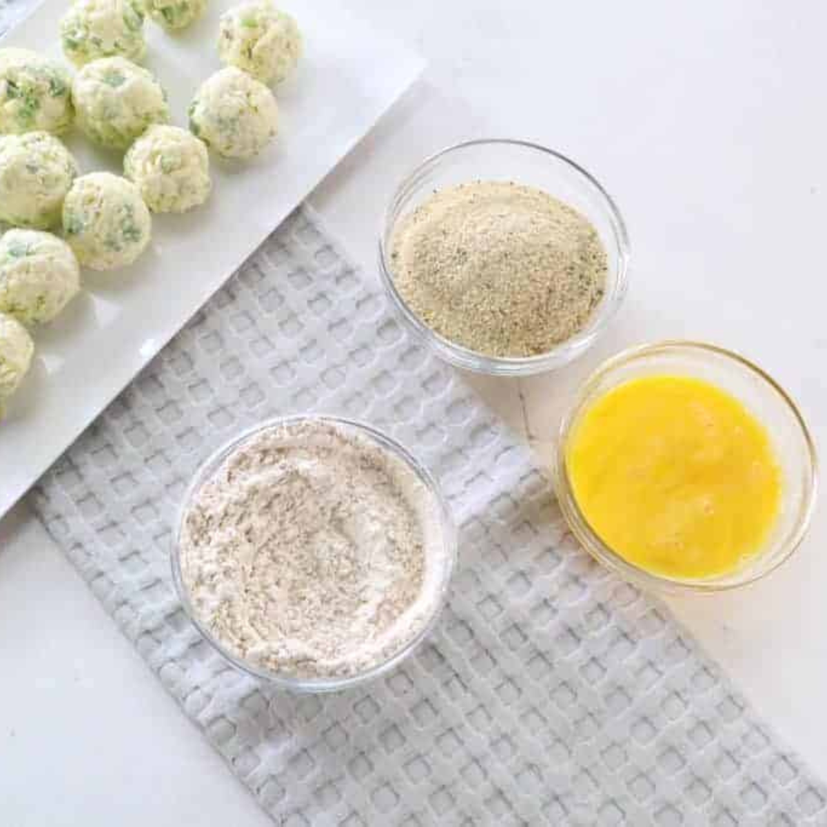 Setting up breading station with flour, eggs, and breadcrumbs in bowls