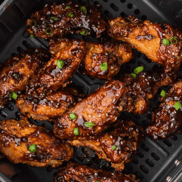 Air fryer Benihana-style Tokyo chicken wings, golden brown and garnished with sesame seeds and green onions.
