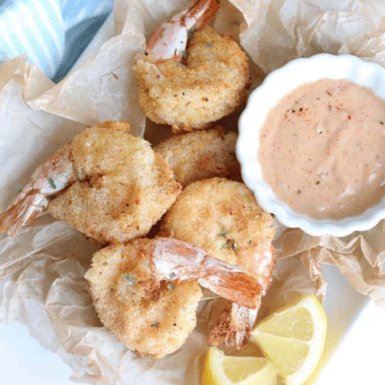 Homemade Mississippi Comeback Sauce in a jar, with a spoon beside it, perfect for dipping fries or seafood.